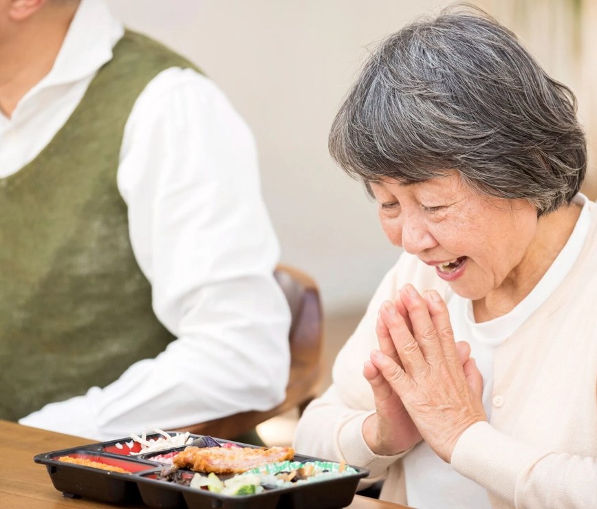 食卓で食事をとる高齢の男性